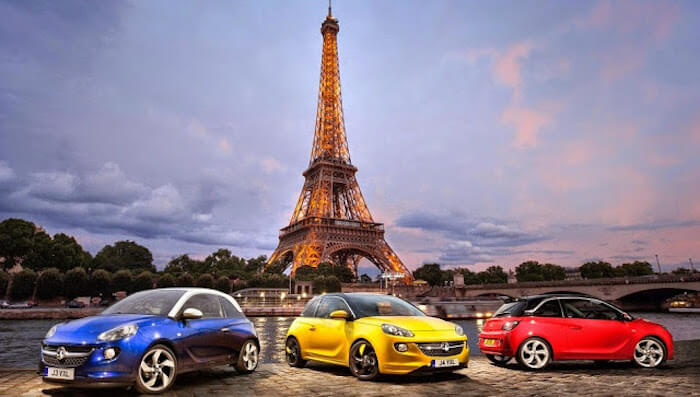 Três carros em frente à Torre Eiffel