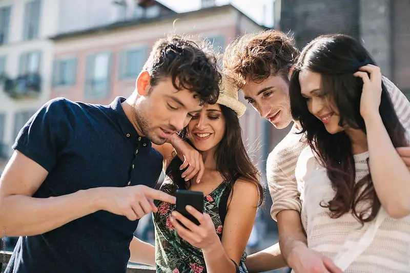 Grupo de jovens usa o celular na cidade