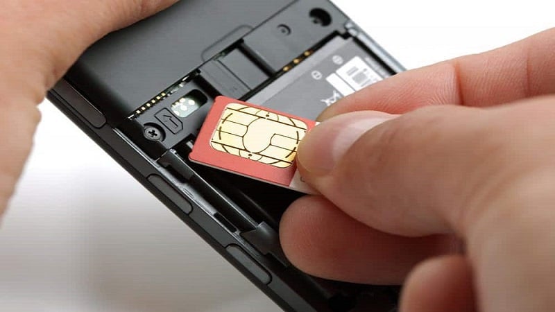 Pessoa coloca o chip de celular em seu aparelho eletrônico.