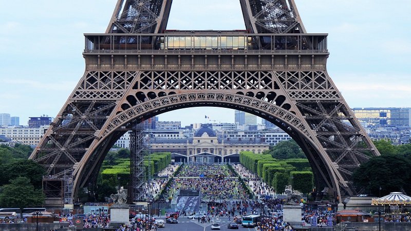 Vista aproximada da Torre Eiffel em Paris com as ruas agitadas abaixo dela