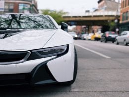 Carro branco estacionado em uma rua movimentada