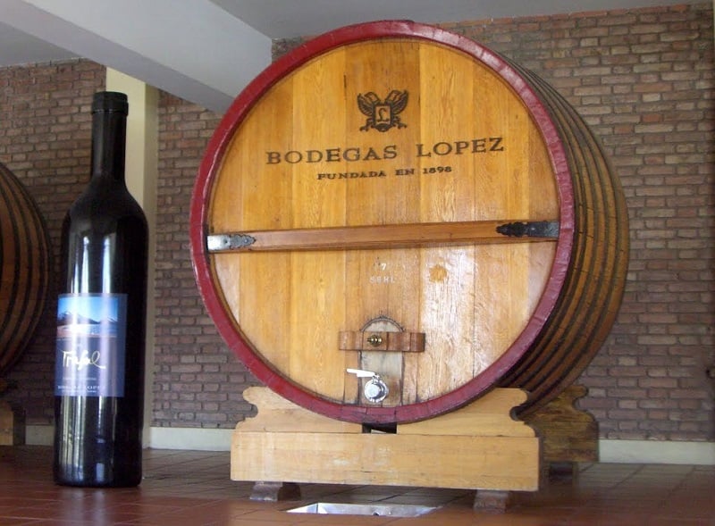 Barril da Bodega López com uma garrafa de vinho ao lado