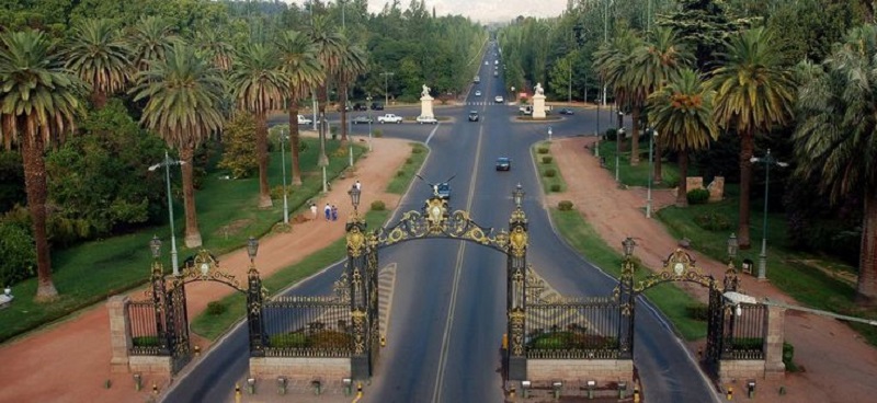 Vista do Parque General San Martin, nota-se uma estrada com portões do parque e palmeiras ao redor