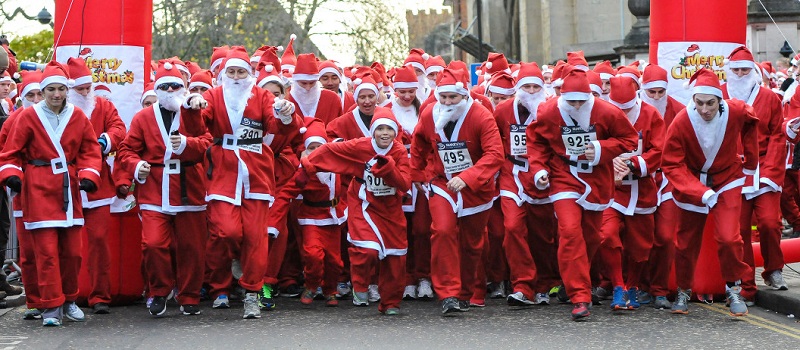 Pessoas correm fantasiadas de Papai Noel na Santa Run