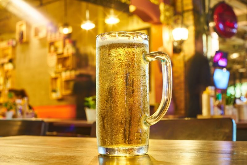 Uma caneca de cerveja em cima de um balcão de um bar