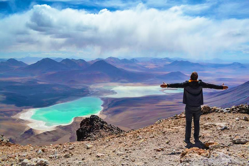 Turista de braços aberto admirando uma vista da paisagem natural de San Pedro Atacama