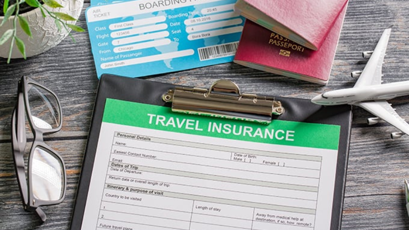 Papeis importantes do seguro viagem em uma mesa com passaportes, óculos, e pequenos itens decorativos.