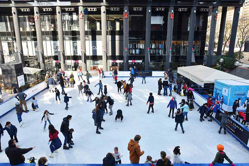 Pessoas patinam em pista de patinação do gelo em Pedralbes, Barcelona.