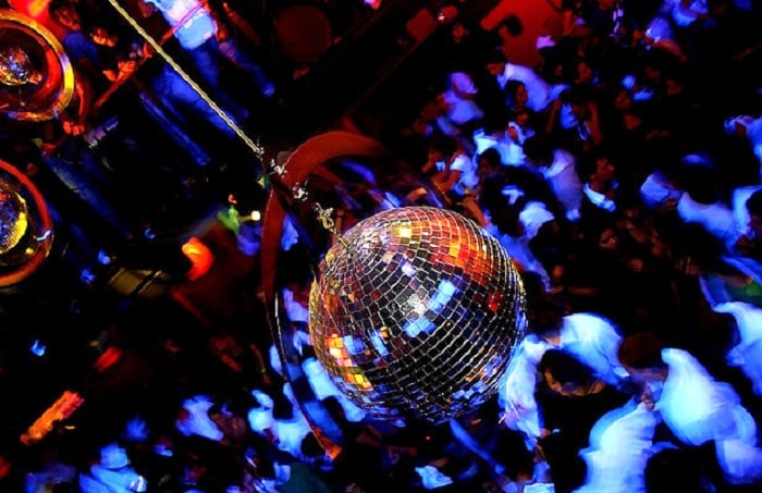 Pessoas dançam na balada Tenax em Florença. Nota-se um globo de discoteca no centro da imagem.