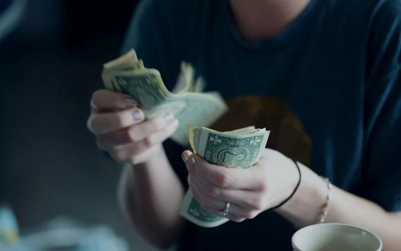 Menina contando dólar em espécie