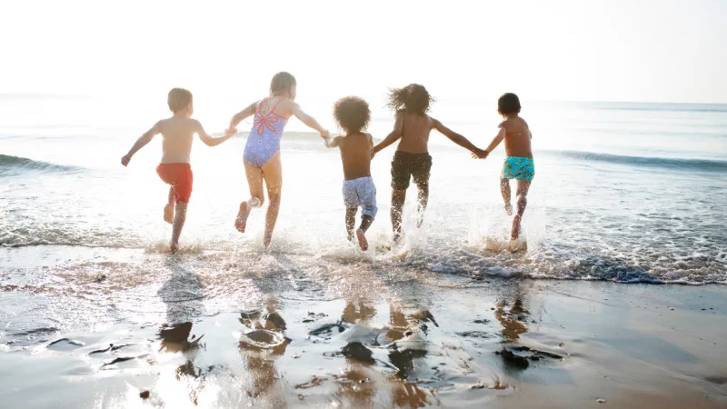 Crianças correndo na praia em Natal