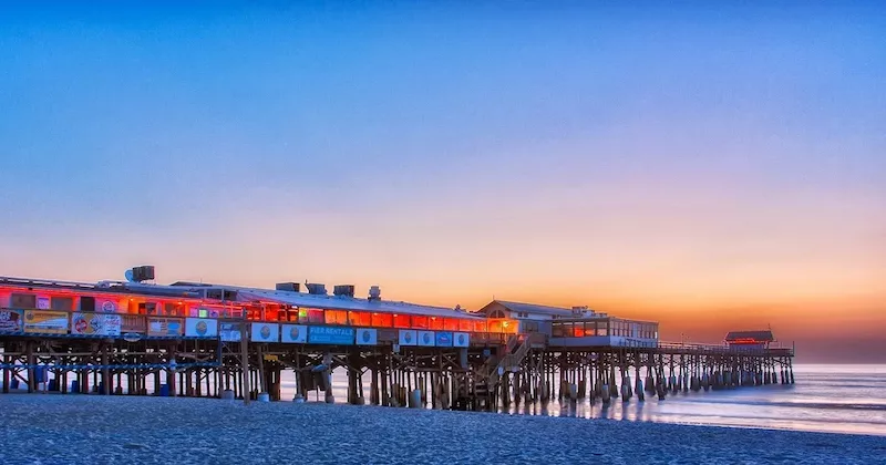 Cocoa Beach Pier iluminado ao anoitecer