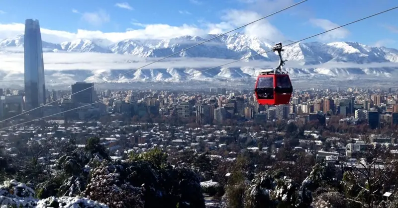 Vista ampla da cidade de Santiago com neve ao fundo