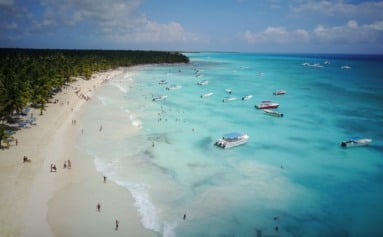 Look from above at turquoise water along golden beach somewhere in Dominican Republic