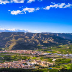 A stunning landscape view of a city surrounded by hills covered with lush vegetation